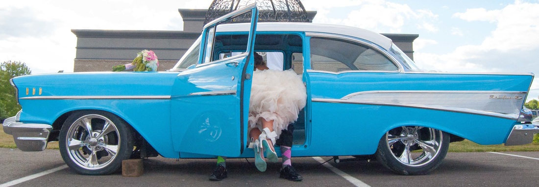 bride on top of groom in car with fun shoes at the bel air